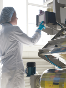 ouvrière agroalimentaire travaillant sur une machine en usine certifiée ifs