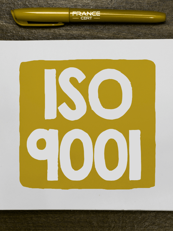 lettres iso 9001 sur fond doré avec un stylo