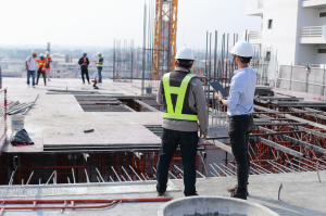 ingénieur et maitre d'oeuvre vérifiant un chantier iso 17020