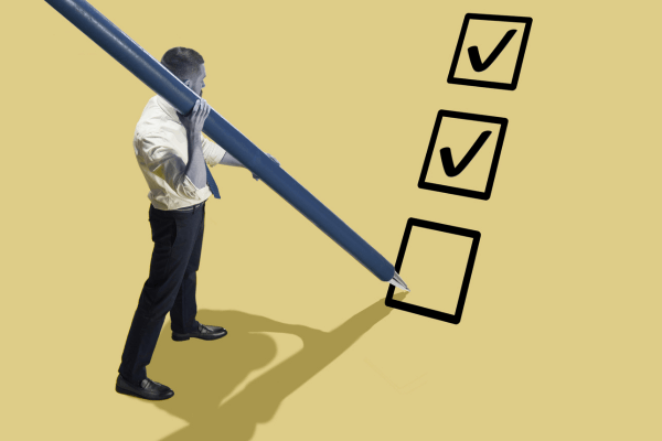 norme qualité - homme tenant un stylo géant et cochant des cases