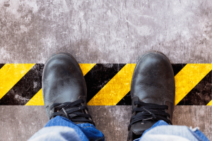 chaussures de sécurité d'ouvrier sur une ligne de démarcation - norme iso 45001